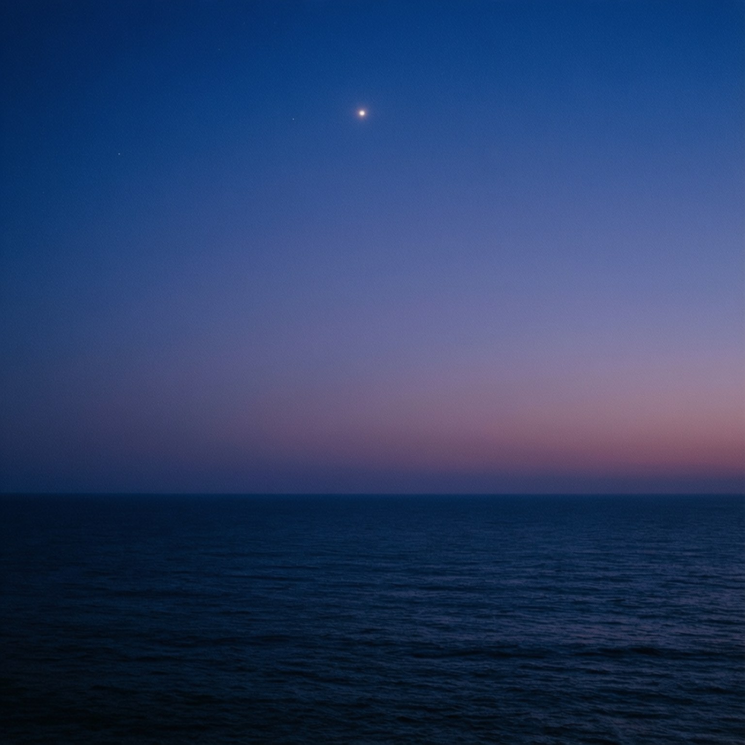 海洋 桌布 壁紙 — 寧靜的暮色海景，星空閃爍，海洋平靜，深藍與紫色漸變的天空。