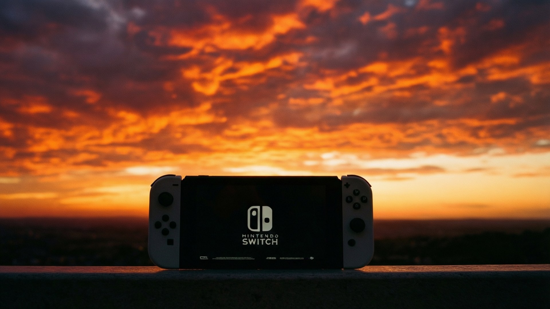 Sunset Silhouette 壁紙 — 一台 Nintendo Switch 主機以剪影形式出現在火熱的橙色和紫色日落天空前。