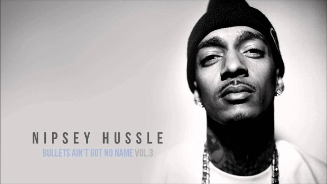 尼普西·哈斯爾 桌布 壁紙 — Nipsey Hussle 戴著毛帽和鏈條的黑白肖像，帶有文字疊加。