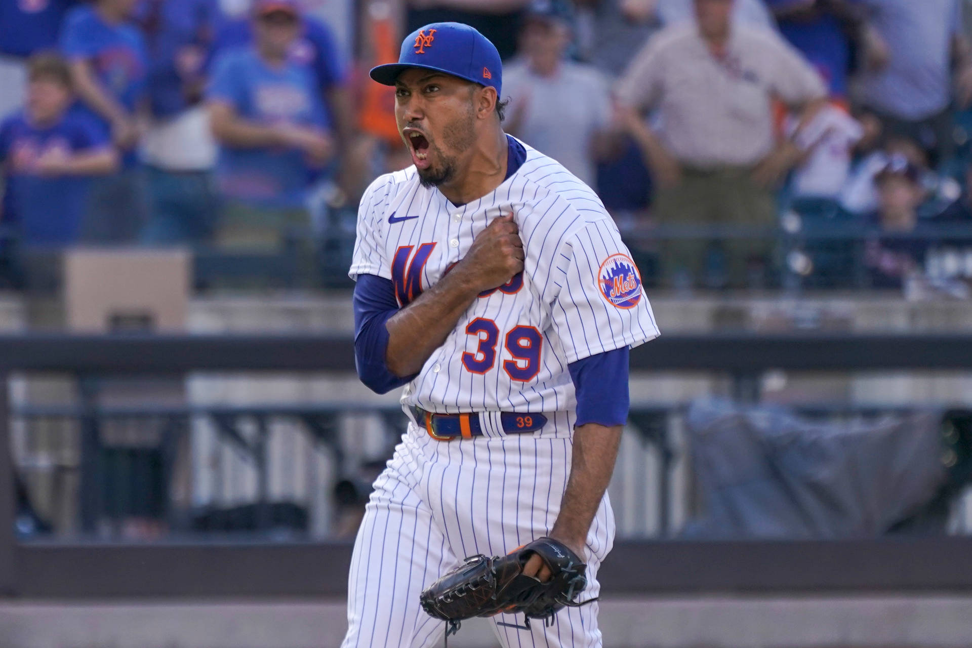 身穿大都會制服的棒球選手在球場上慶祝勝利。 — MLB 壁紙