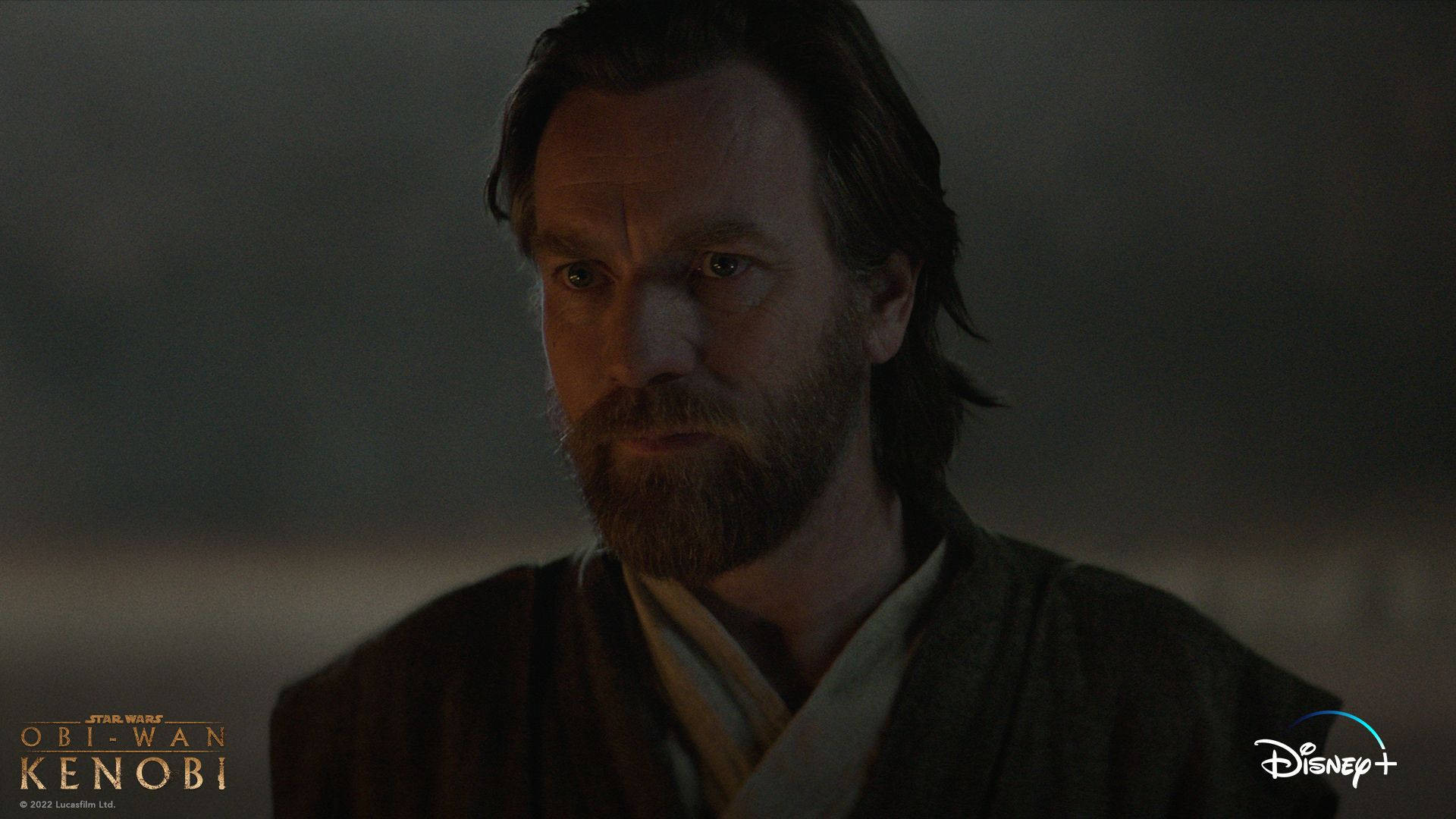 Kenobi 桌布 壁紙 — Obi-Wan Kenobi 在昏暗燈光下的特寫，表情嚴肅。