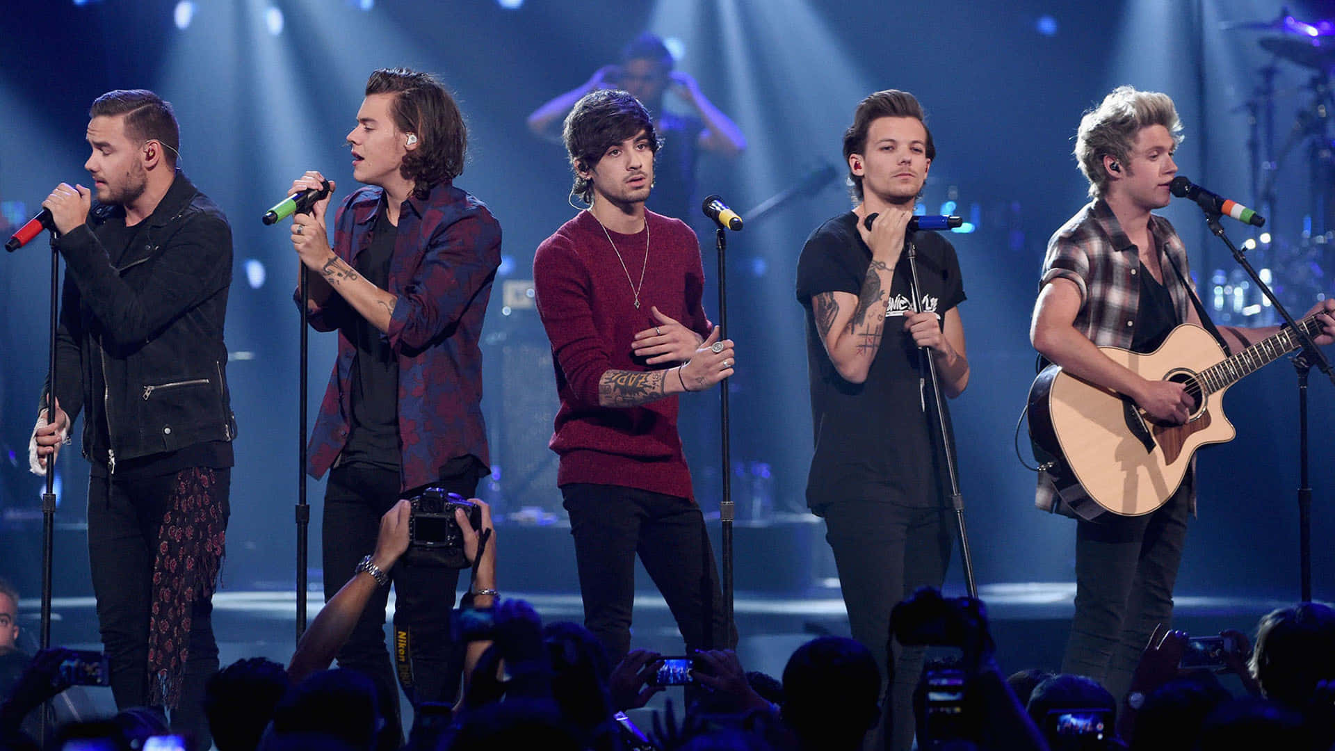 One Direction 桌布 壁紙 — One Direction 在藍色聚光燈下現場表演，粉絲在下方錄影。