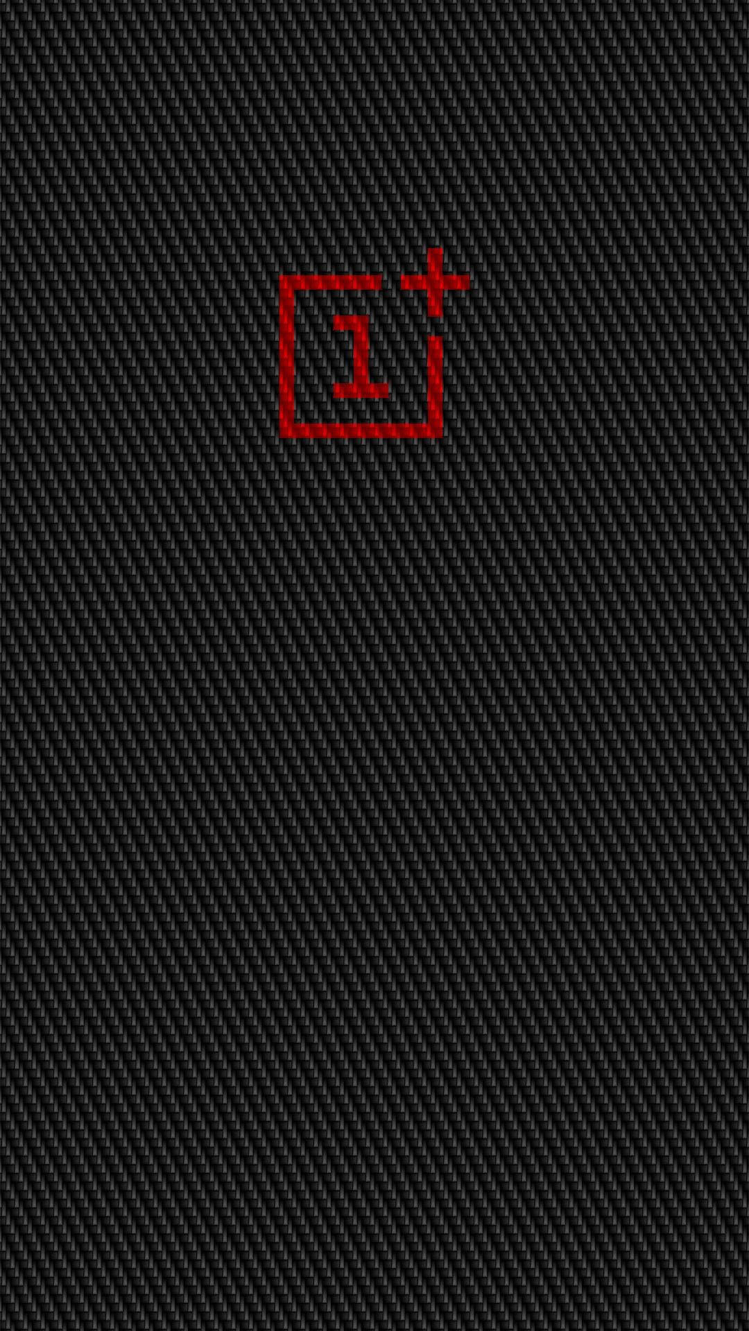 OnePlus 紅色標誌 壁紙 — 一個極簡的紅色OnePlus標誌居中於有紋理的黑色碳纖維背景上。
