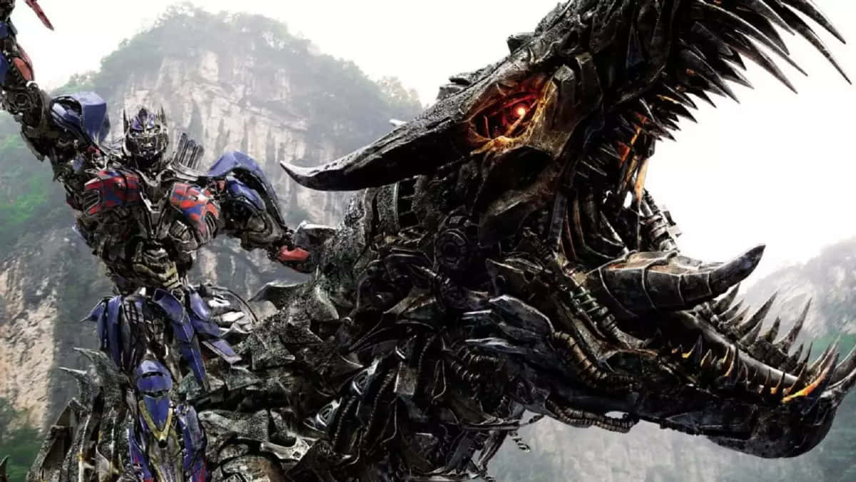 變形金剛 桌布 壁紙 — Optimus Prime 挑釁地站在一隻巨大的機械龍旁邊，背景是霧氣瀰漫的山巒。