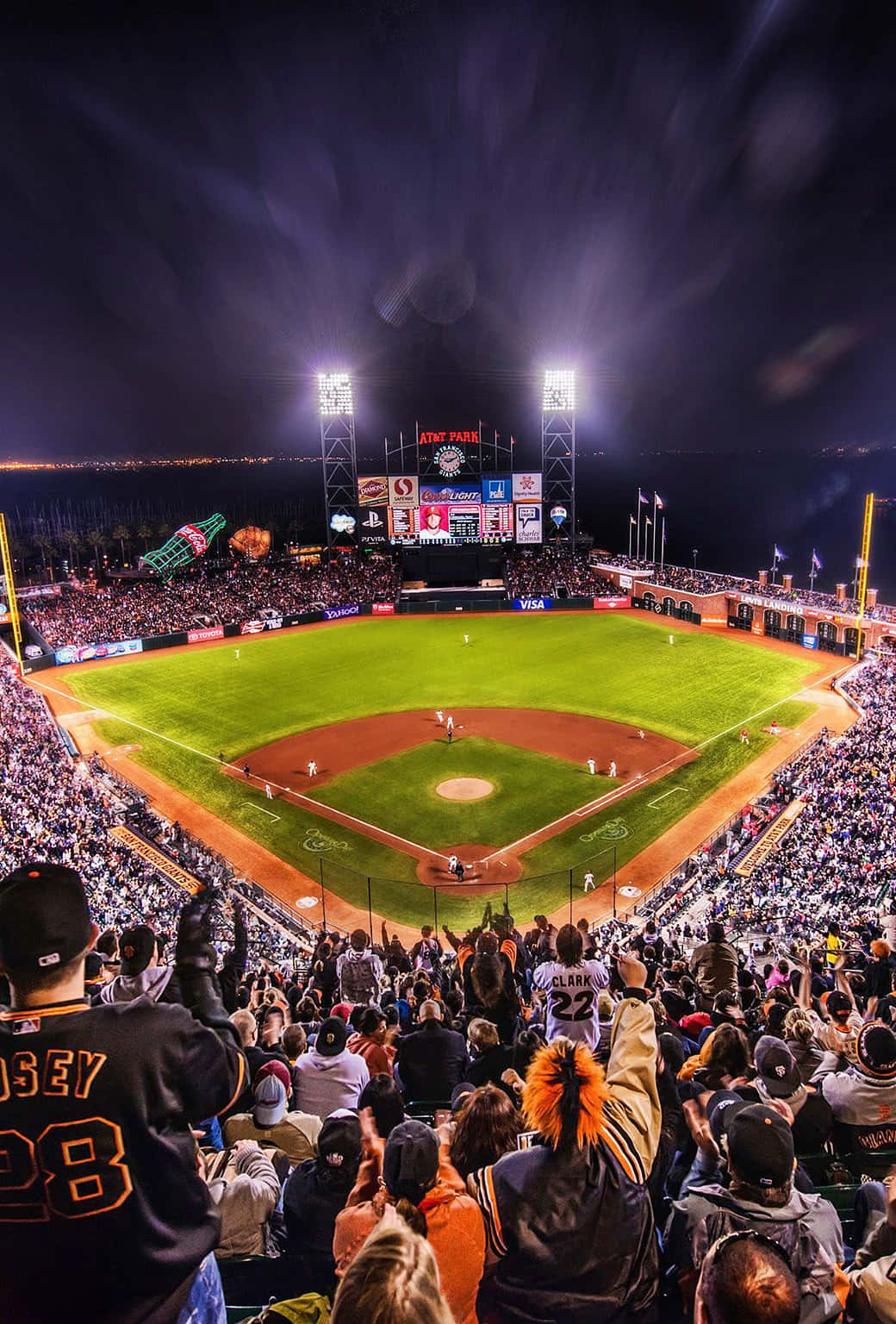 field 桌布 壁紙 — Oracle Park 的一場充滿活力的夜間棒球比賽，球迷在明亮的球場燈光下歡呼。
