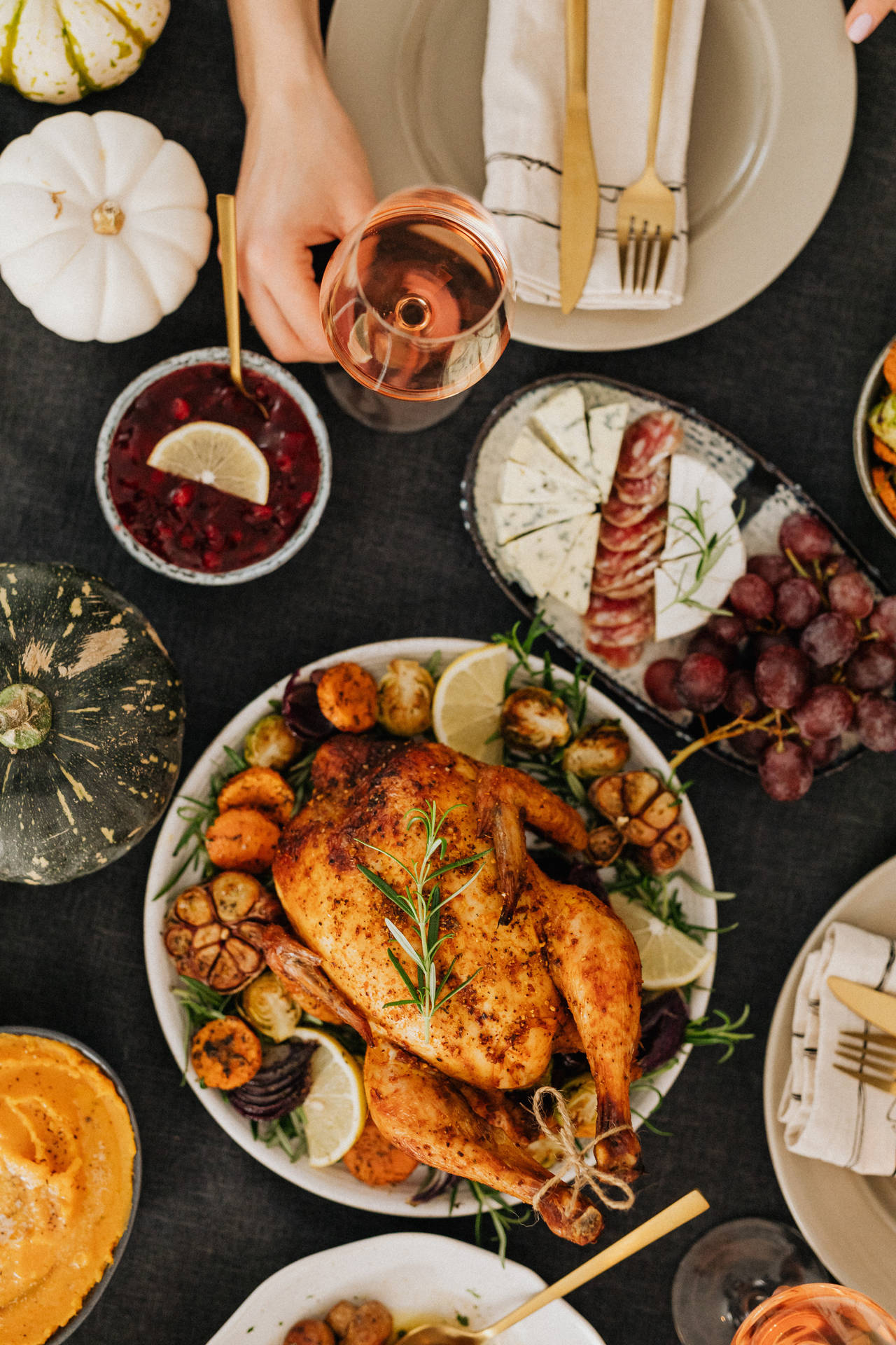 Thanksgiving table with roasted turkey cranberry sauce and autumnal decor.