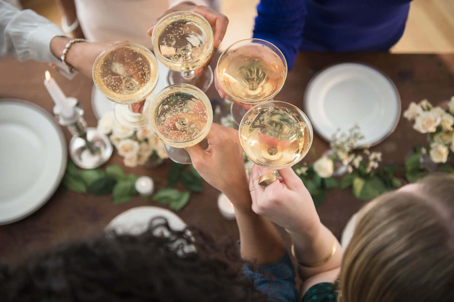 醉意朦朧 桌布 壁紙 — Overhead view of friends clinking champagne glasses in a celebratory toast at a warmly lit dinner table.