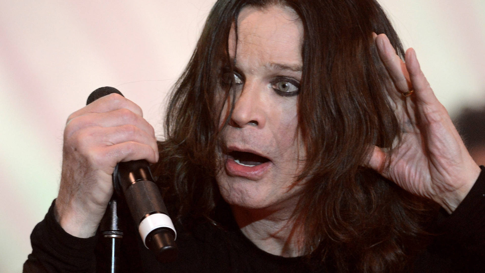 Ozzy Osbourne 桌布 壁紙 — Ozzy Osbourne 熱情地對著麥克風唱歌，眼神專注，一隻手舉在頭部附近。