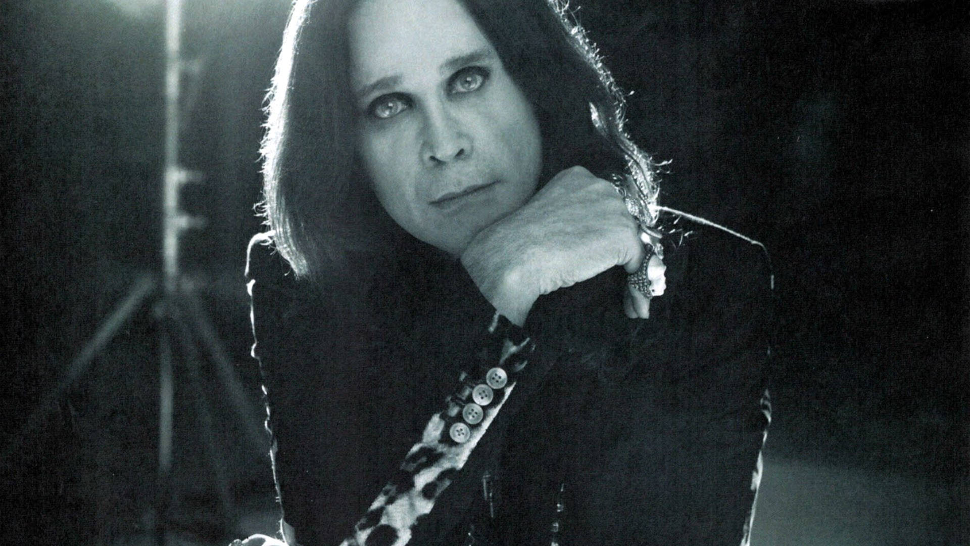 Ozzy Osbourne 桌布 壁紙 — Ozzy Osbourne 用蒼白的眼睛凝視，下巴擱在手上，一幅戲劇性的黑白肖像。
