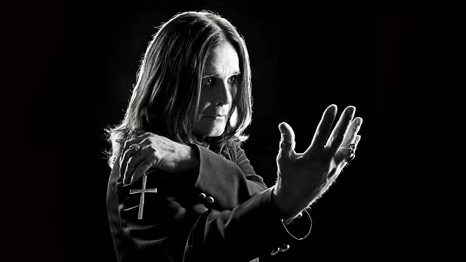 Ozzy Osbourne 桌布 壁紙 — Ozzy Osbourne 長髮戴戒指，在黑色背景前強烈凝視，高對比黑白照片。