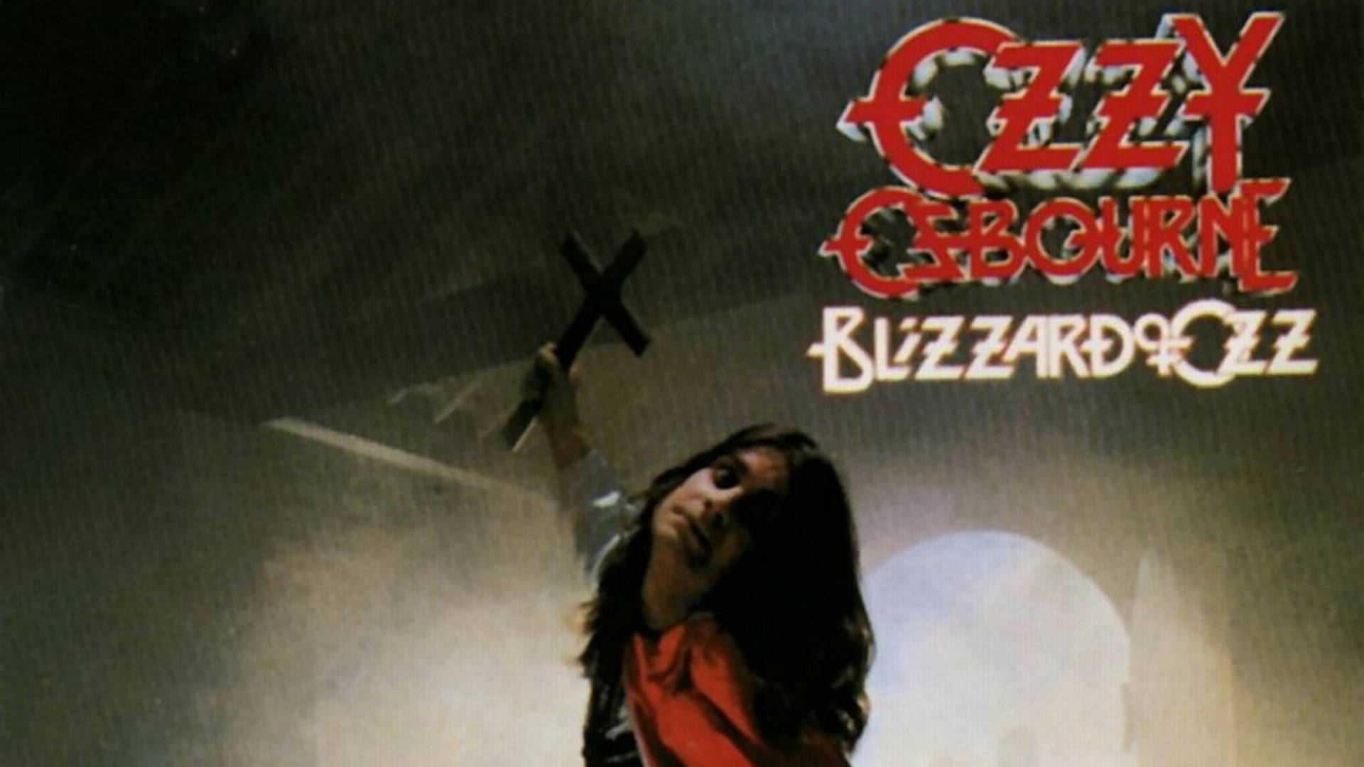 Ozzy Osbourne 桌布 壁紙 — Ozzy Osbourne 高舉黑色十字架，背景煙霧瀰漫，他的專輯標題以紅色和白色發光。