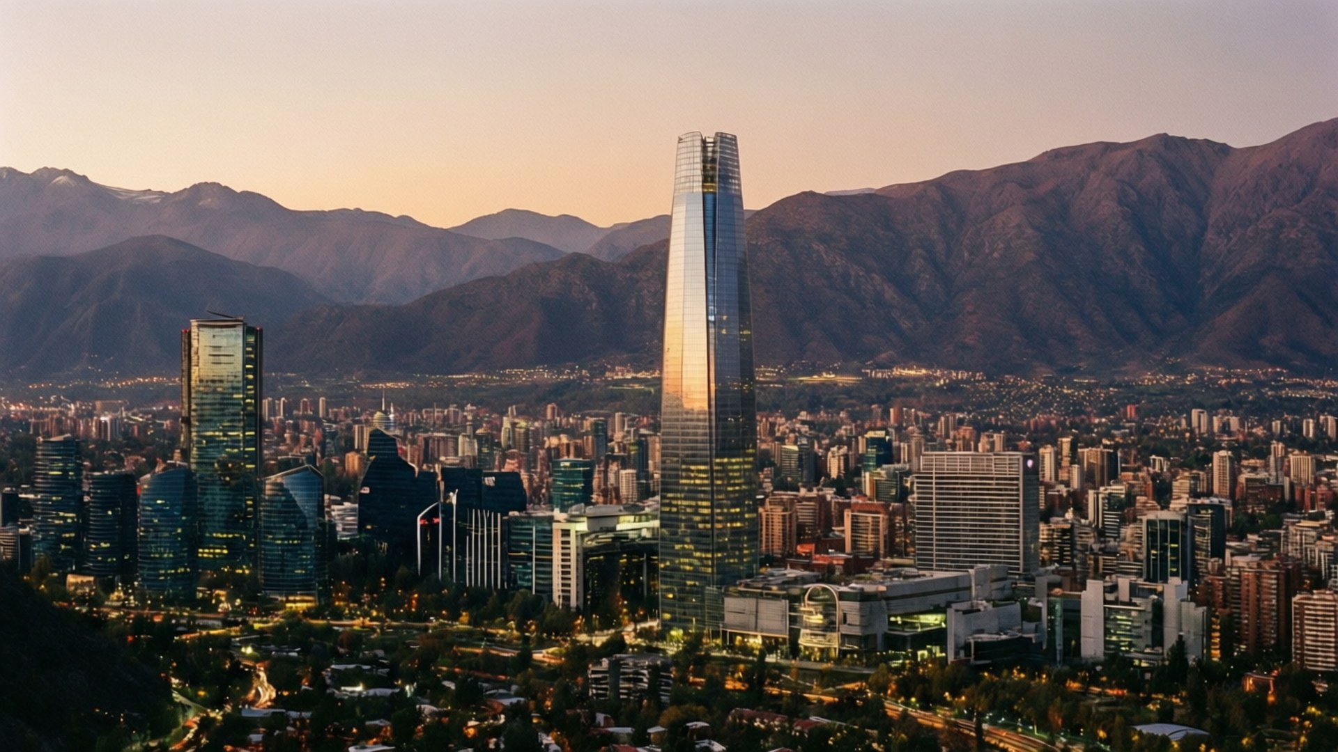 Santiago Skyline at Dusk 壁紙 — 聖地牙哥智利天際線的日落全景，以托雷科斯塔內拉為主導，背景是白雪覆蓋的山脈。