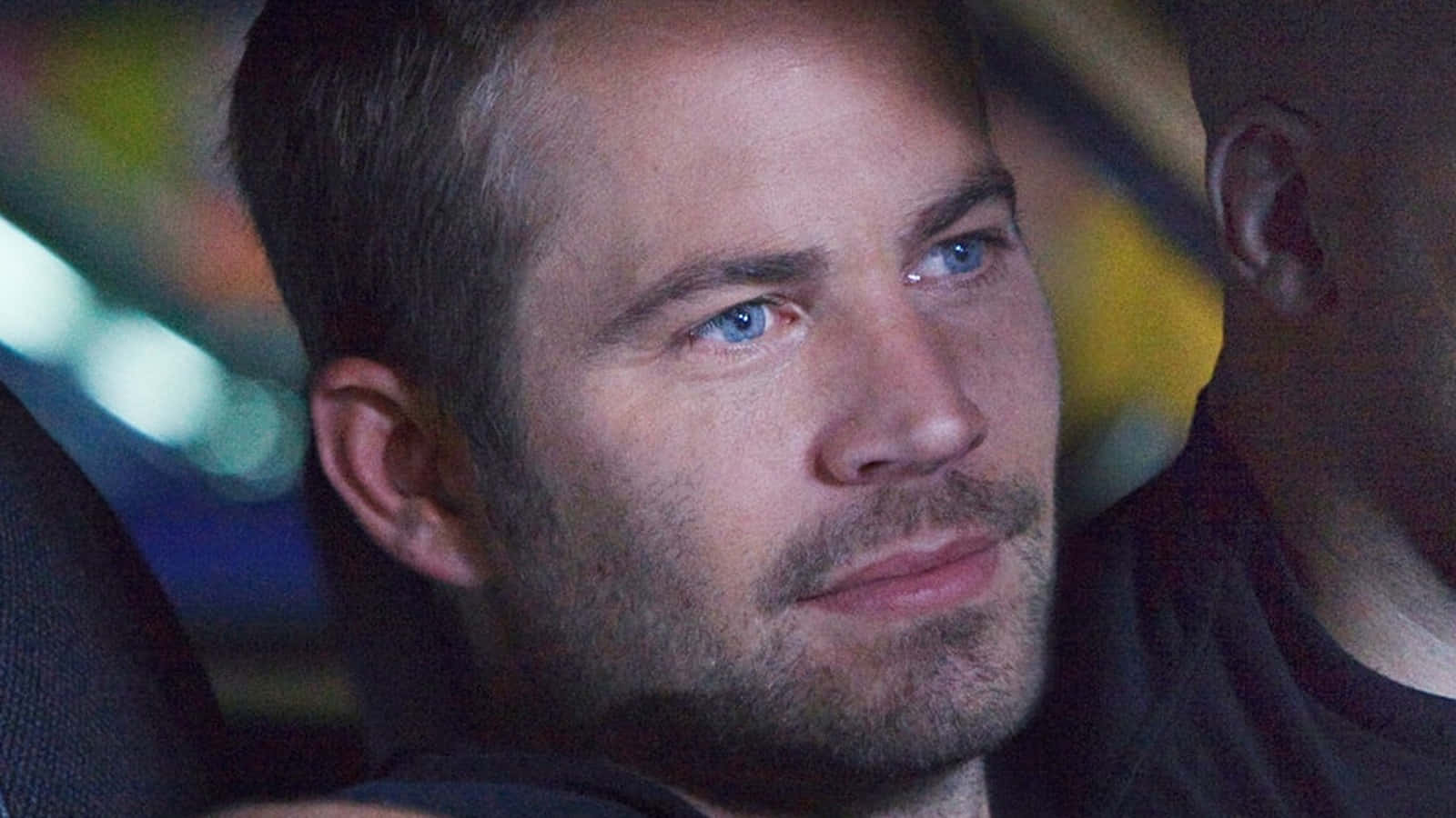 玩命關頭 桌布 壁紙 — Paul Walker 在夜間車內的近距離特寫，身後有模糊的彩色燈光。