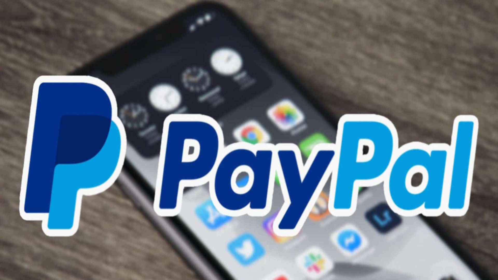 PayPal 桌布 壁紙 — PayPal 標誌顯眼地顯示在一個顯示應用程式圖標的智慧型手機上，置於木質表面。