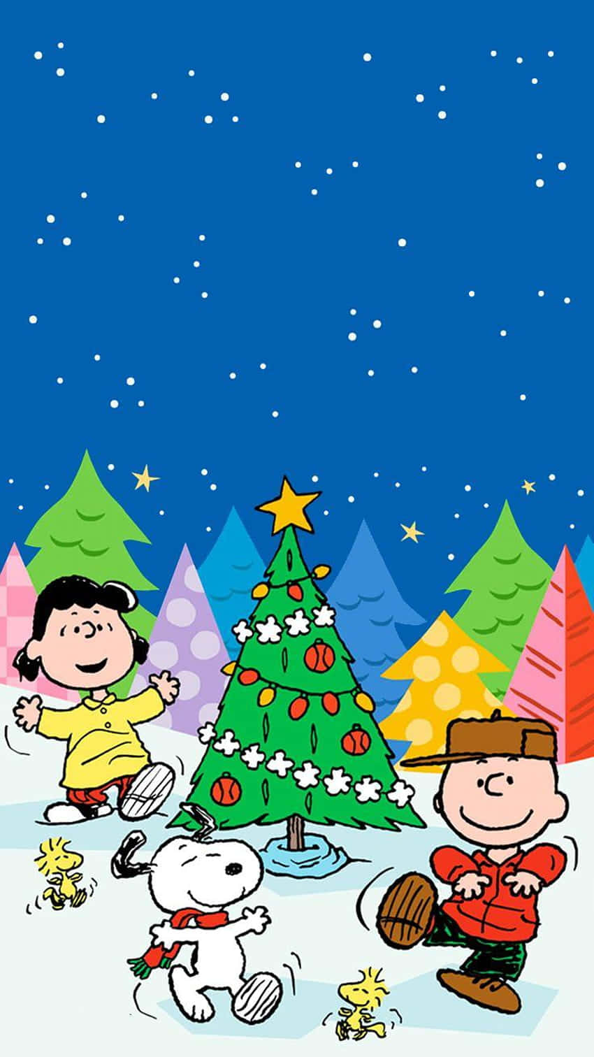 查理布朗 動圖 桌布 壁紙 — Peanuts 角色們愉快地聚集在一棵裝飾好的聖誕樹周圍，背景是雪花飄飄的星空夜晚。