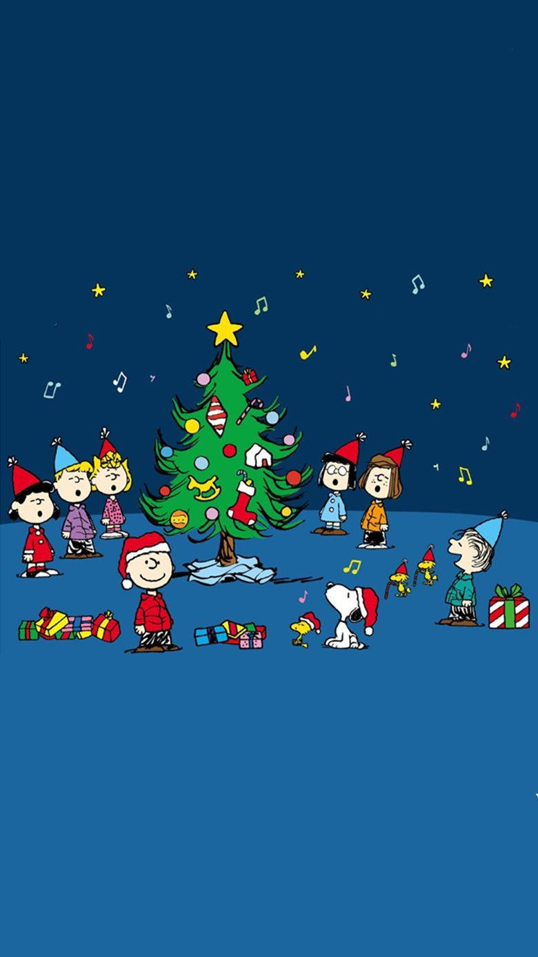 聖誕節 桌布 壁紙 — Peanuts 角色聚集在裝飾好的聖誕樹周圍，背景是繁星點點的夜空，有飄落的音符和星星。