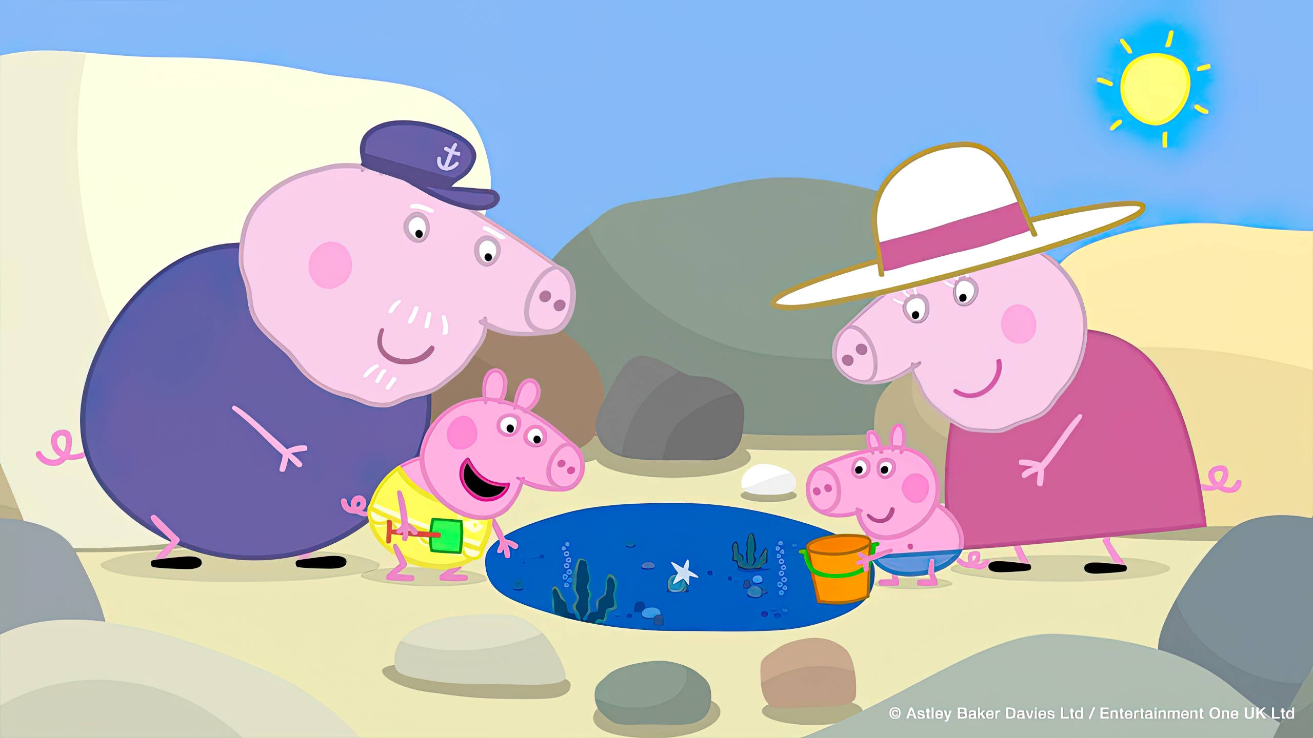 peppa pig tablet 桌布 壁紙 — Peppa Pig 和家人快樂地探索一個有小型水池和岩石的陽光沙灘。