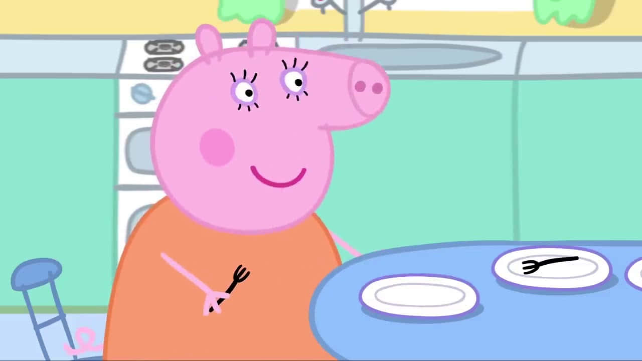 Mummy Pig 桌布 壁紙 — Peppa Pig 在廚房裡開心微笑，拿著叉子，坐在藍色桌子旁，桌上有盤子。