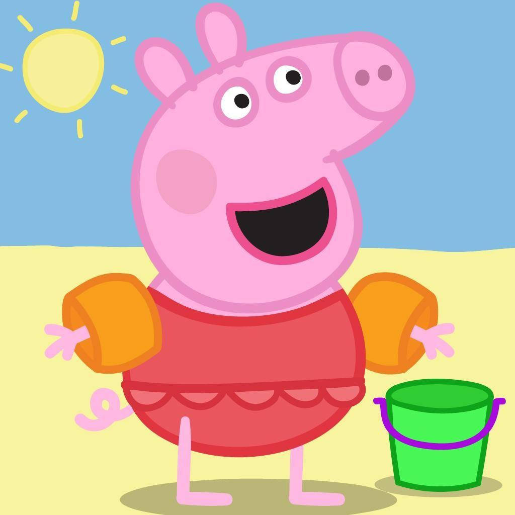 Peppa Pig 穿著紅色泳衣和橙色浮水袖，在陽光明媚的海灘上與綠色水桶一起。 — 佩佩豬 GIF 壁紙