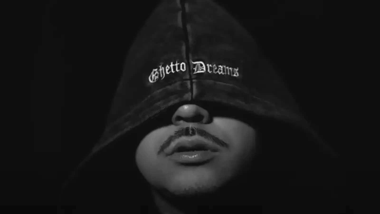  壁紙 — 一個人穿著黑色連帽衫，眼睛上方繡有「Ghetto Dreams」字樣，在鮮明的黑白肖像中直視前方。