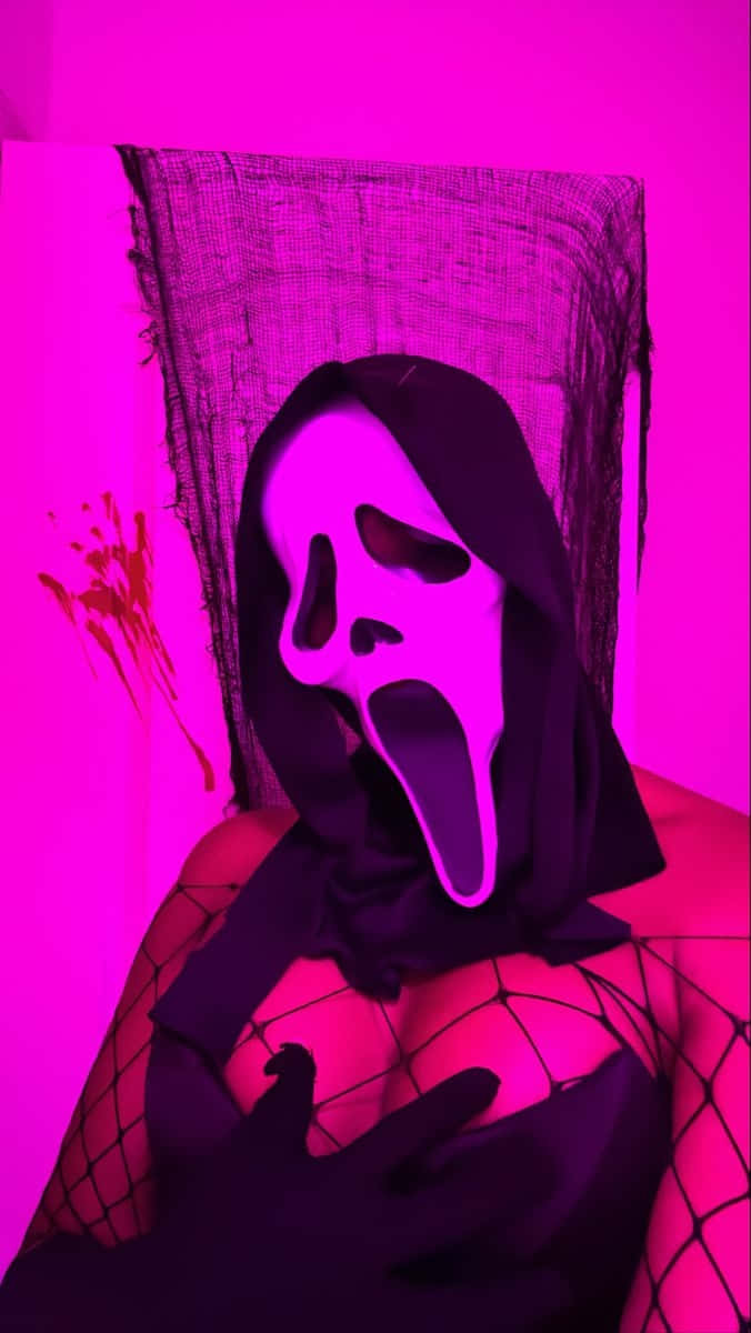  壁紙 — 一個人戴著Ghostface面具和黑色魚網裝，站在有血跡和黑色網的鮮粉紅色牆前。
