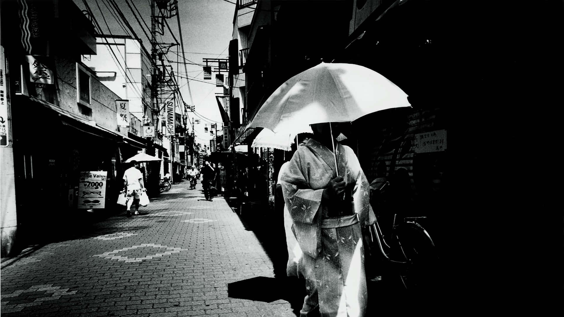 穿著和服拿傘的人走在狹窄的日本街道上 — 日本黑白 壁紙