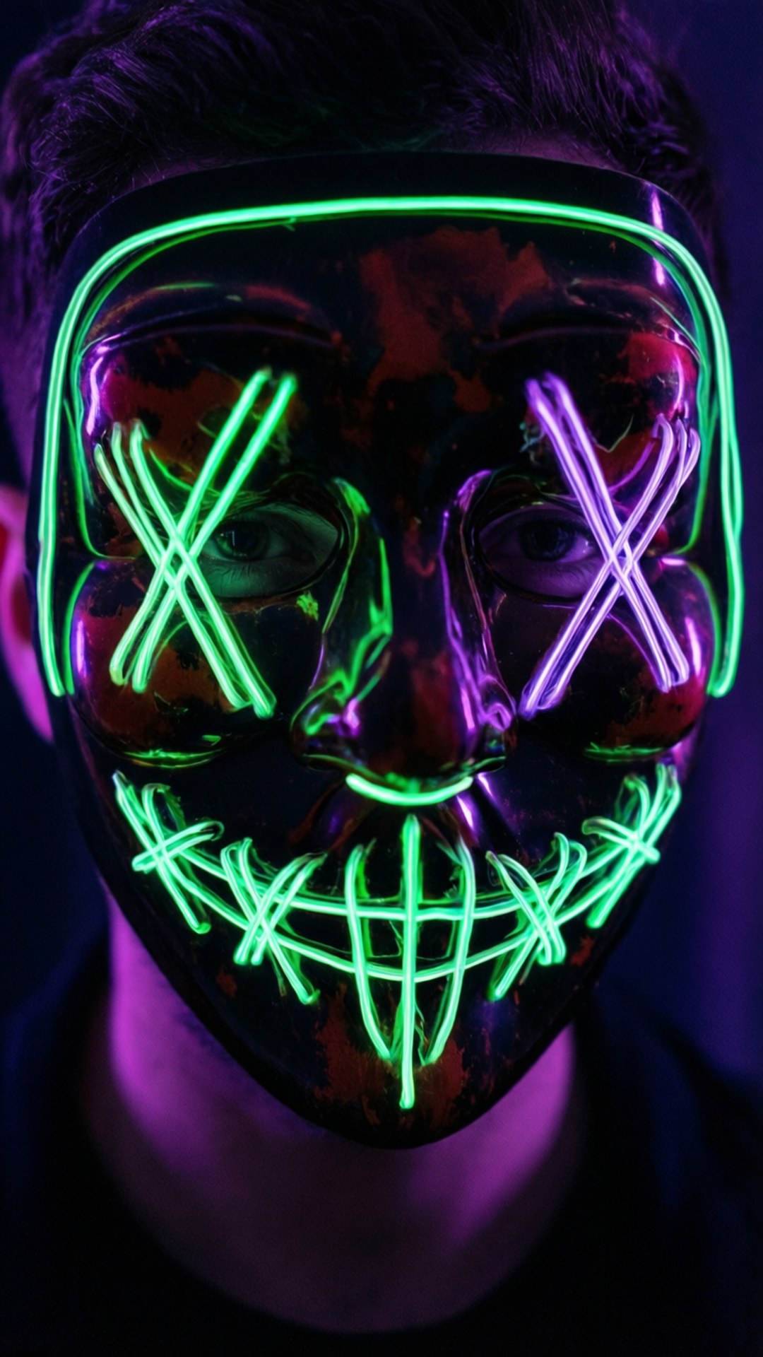 Neon Mask 壁紙 — 一個人戴著光澤的黑色面具，帶有發光的綠色和紫色霓虹燈，在眼睛上形成X形狀和縫合的笑容。
