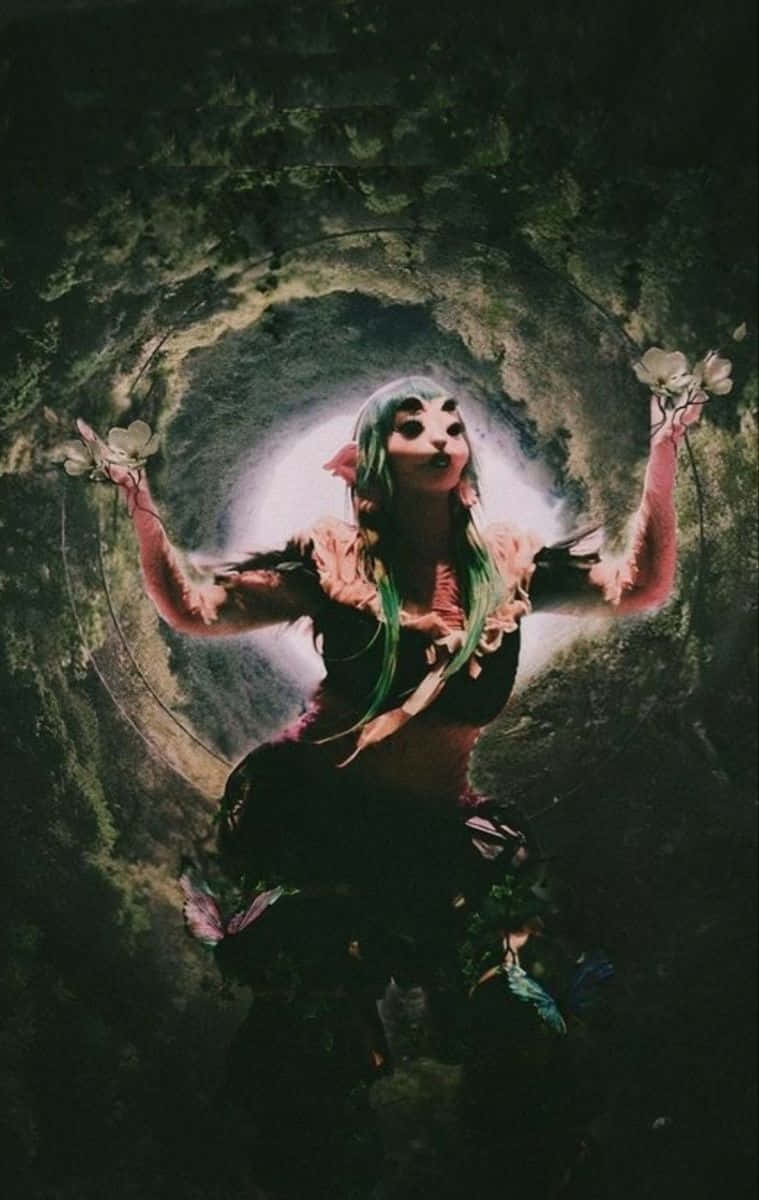  壁紙 — 一個綠髮、身穿花卉服飾的人站在長滿苔蘚的隧道中，手持白色花朵，背後有明亮的光芒照射。