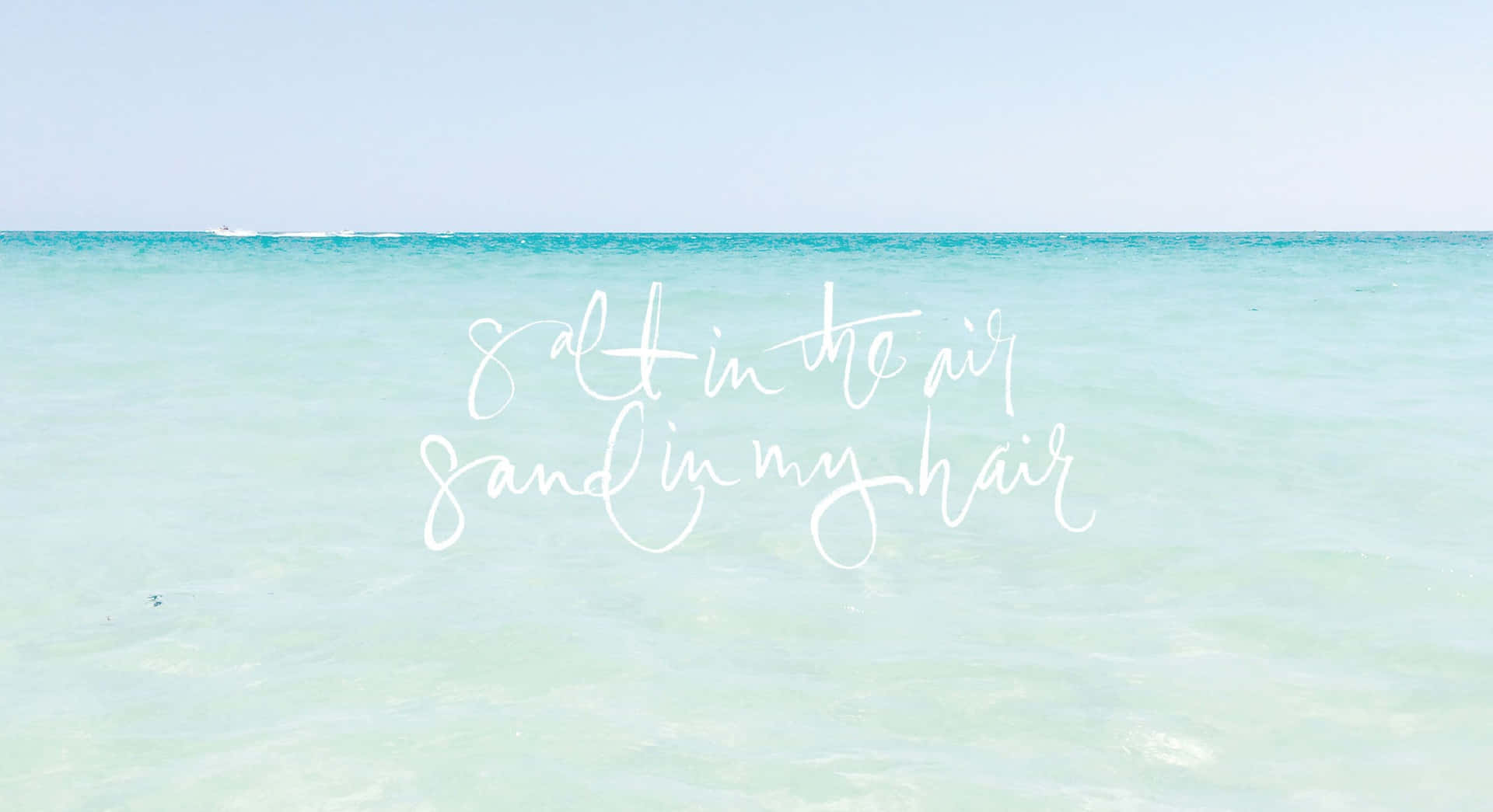 平靜的藍綠色海洋上白色字體寫著 salt in the air sand in my hair。 — Pastel 壁紙