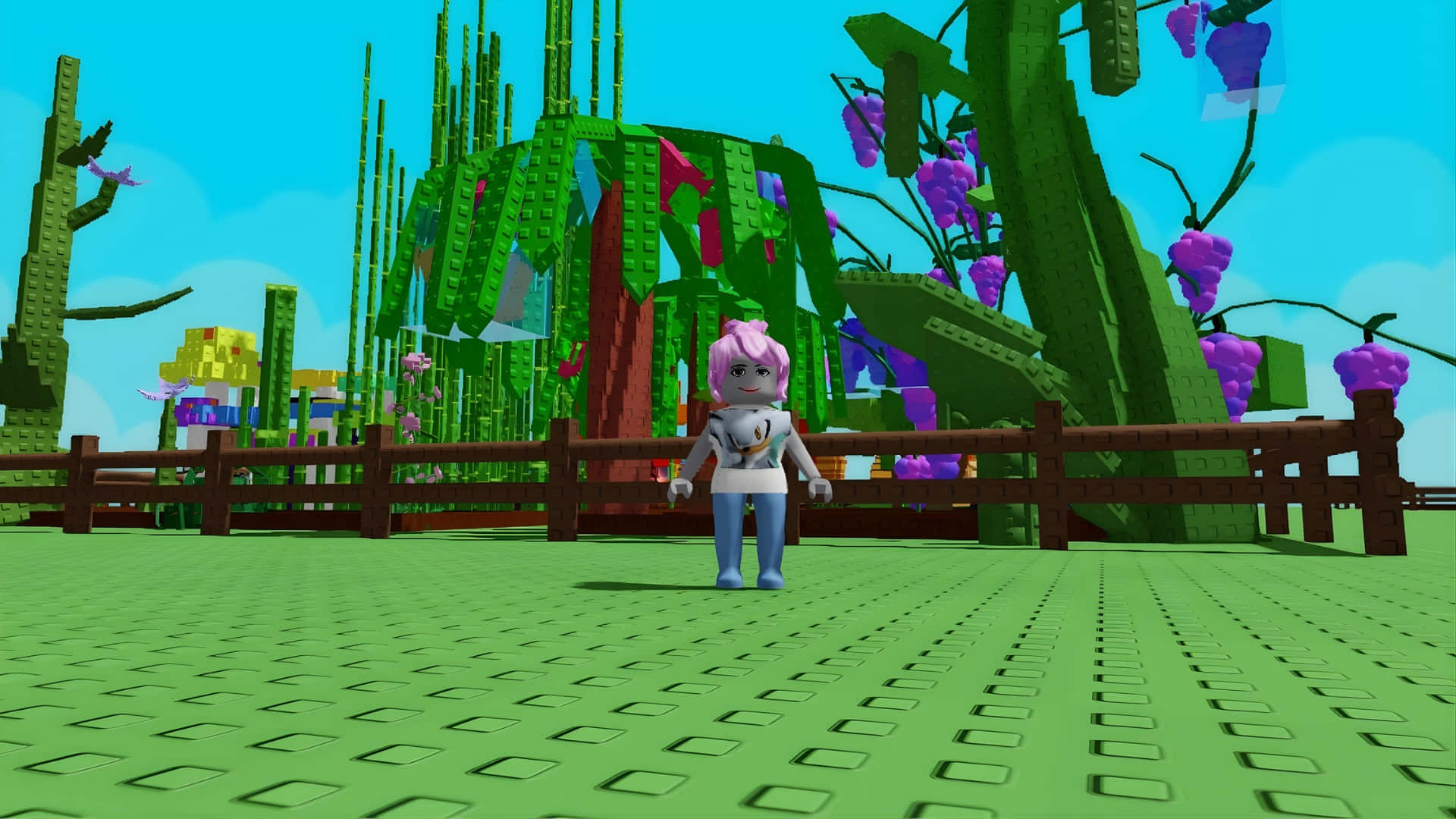  壁紙 — 一個粉紅色頭髮的虛擬角色站在一個色彩繽紛的方塊花園中，花園裡有紫色葡萄和綠色樹木，天空湛藍。
