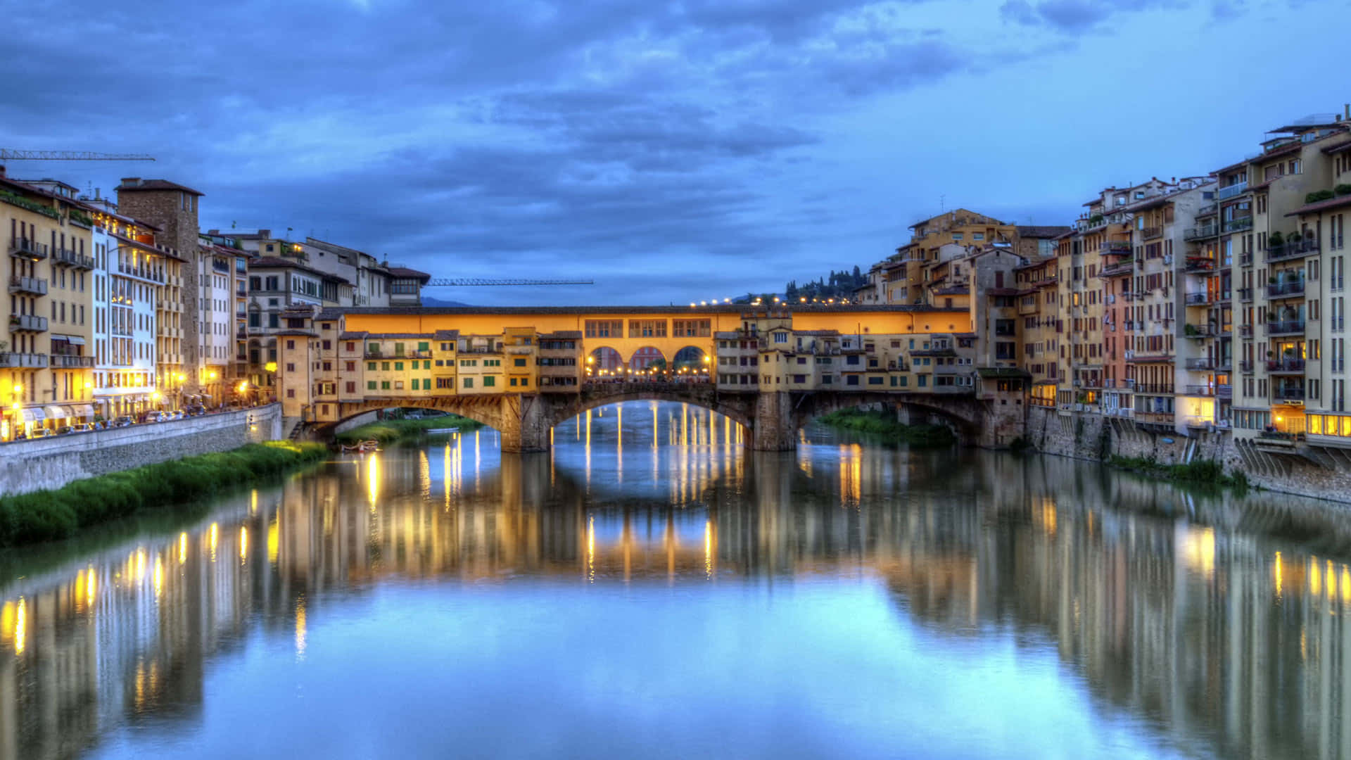 夜空 桌布 壁紙 — Ponte Vecchio橋在黃昏時分溫暖地照耀著阿諾河，歷史建築倒映在平靜的水面上。