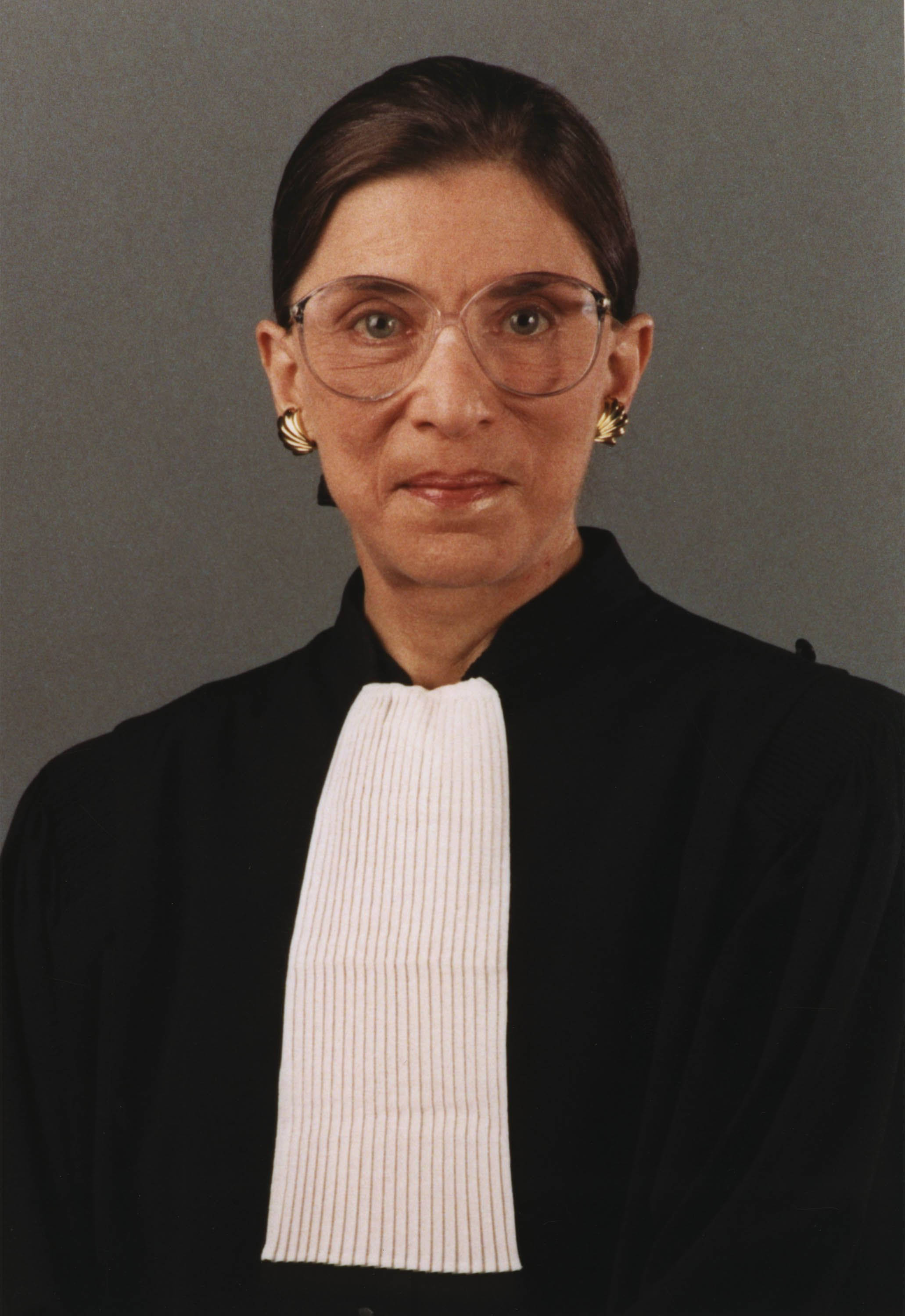 Ruth Bader Ginsburg 桌布 壁紙 — Ruth Bader Ginsburg 身穿司法長袍、白色領飾和金色耳環，以灰色背景為襯的肖像。