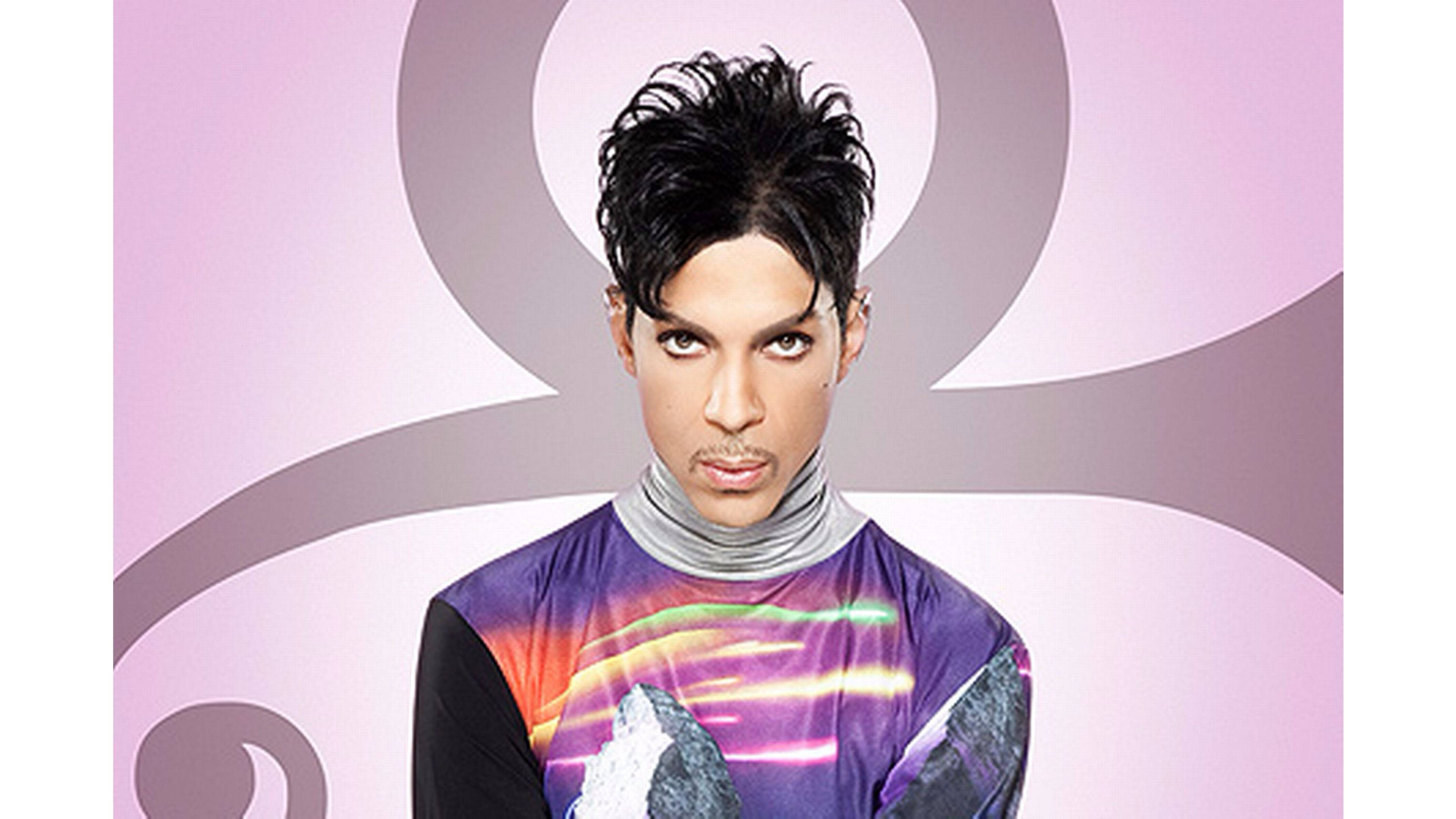Prince 桌布 壁紙 — Prince 穿著鮮豔的紫色彩虹襯衫，在柔和的粉紅色抽象背景前凝視。