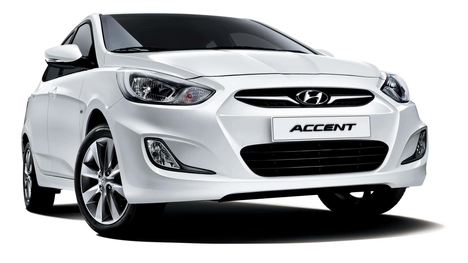 Hyundai Accent 桌布 壁紙 — 一輛純白色的現代雅尊緊湊型轎車，在攝影棚拍攝中展現簡潔線條和現代化頭燈。
