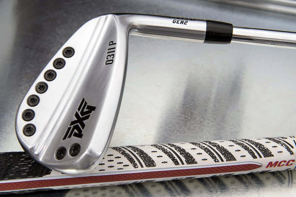 Golf Club 桌布 壁紙 — PXG GEN2 高爾夫球桿特寫，銀色桿頭和黑色握把放置在反光金屬表面上。