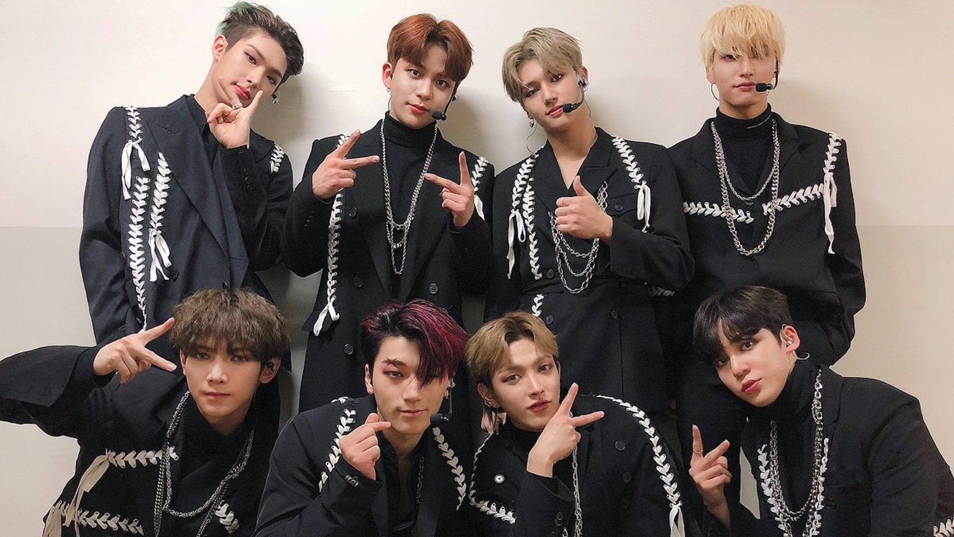 七位時尚年輕男士身穿搭配黑色服裝，在攝影棚中自信地擺姿勢。 — K Pop 壁紙