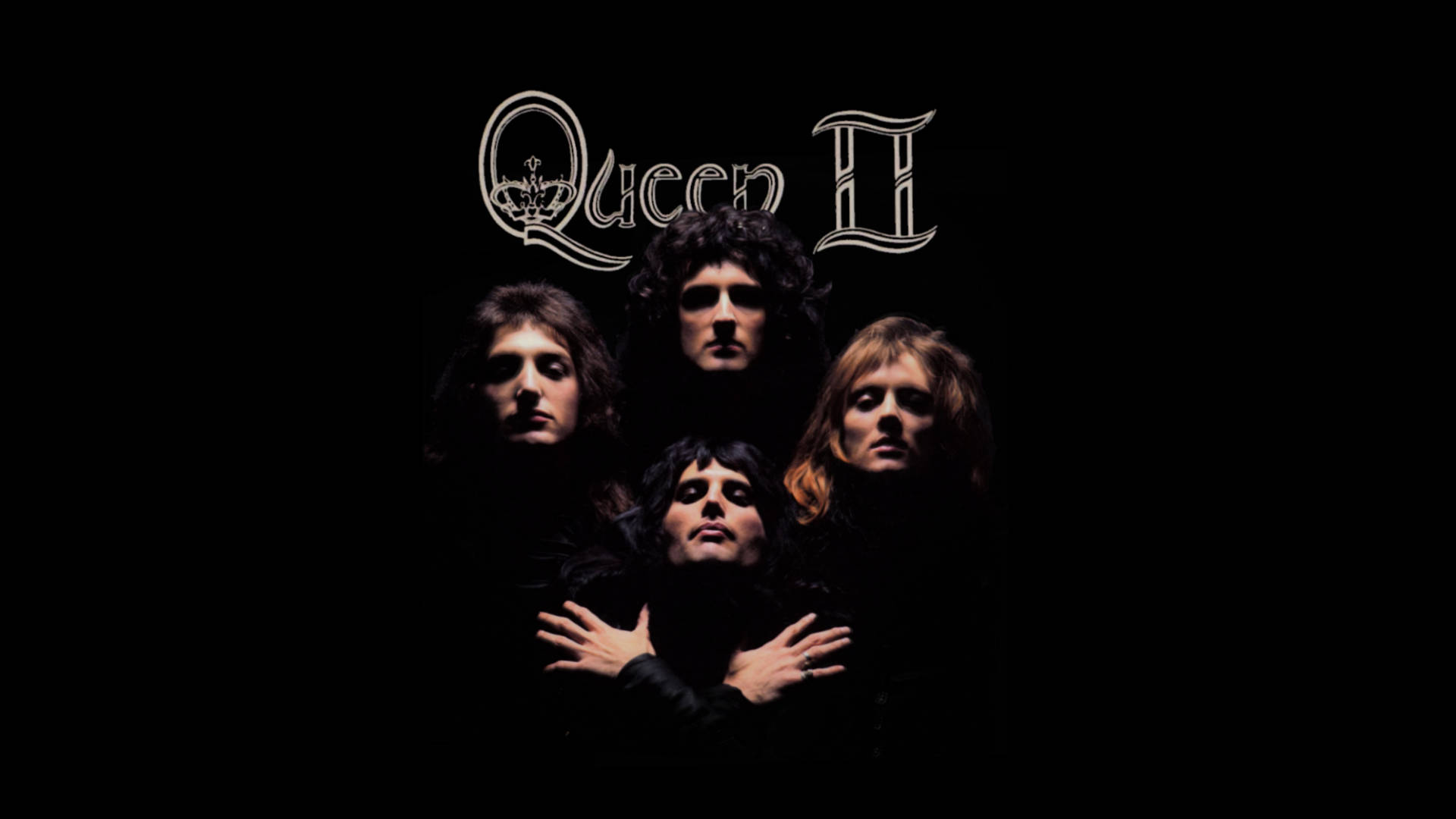 女王 桌布 壁紙 — Queen II 的四位樂隊成員在黑色背景前凝視，上方有華麗的白色字體專輯標題。