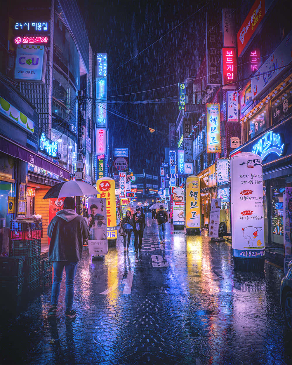  壁紙 — 夜晚被雨水浸濕、霓虹燈照亮的小巷，行人撐著雨傘，在發光的韓文招牌下，招牌倒映在濕漉漉的路面上。
