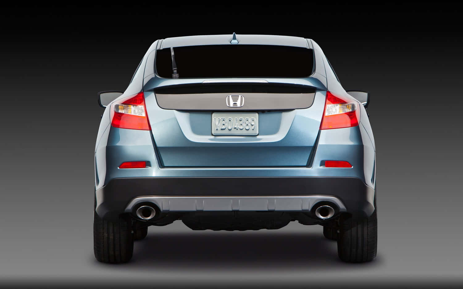 Honda Crosstour 桌布 壁紙 — 一輛時尚藍色本田轎車的後視圖，配備雙排氣管，背景為深色漸變工作室背景。