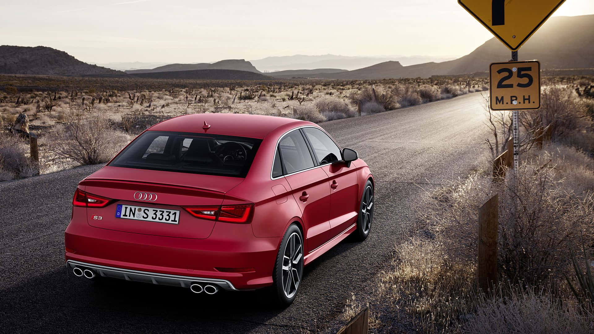 Audi S3 桌布 壁紙 — 一輛亮紅色的Audi S3轎車停在沙漠公路上，旁邊有25 M.P.H.標誌，遠山在朦朧的天空下。
