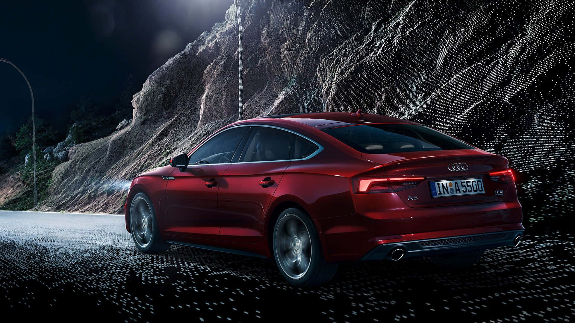 Audi A5 桌布 壁紙 — 一輛時尚的紅色奧迪轎車在戲劇性的夜間燈光下沿著蜿蜒的山路行駛，背景是崎嶇的懸崖。
