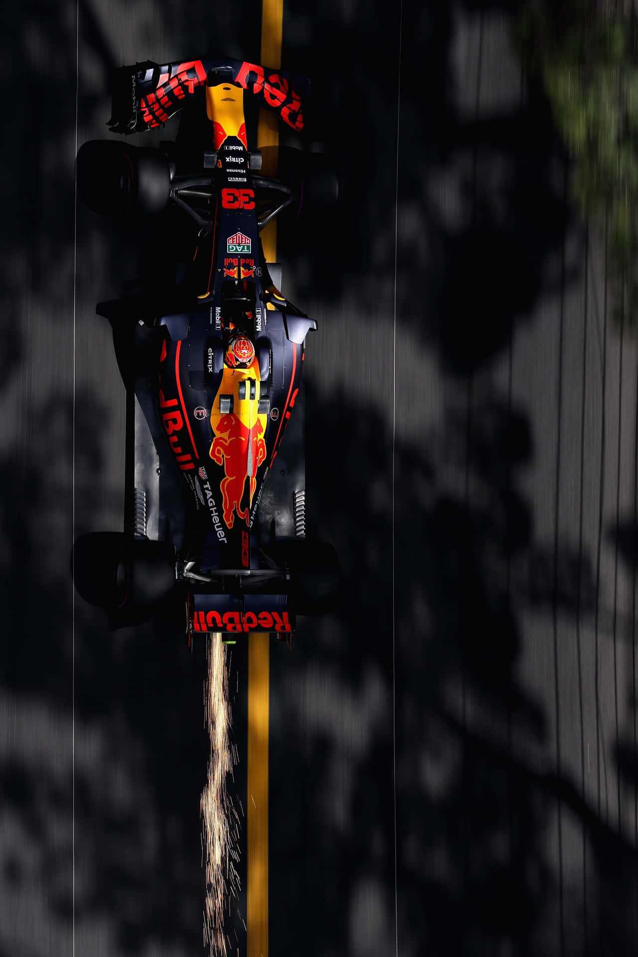 紅牛F1賽車在黑暗賽道上高速行駛，輪胎冒煙。 — F1 壁紙