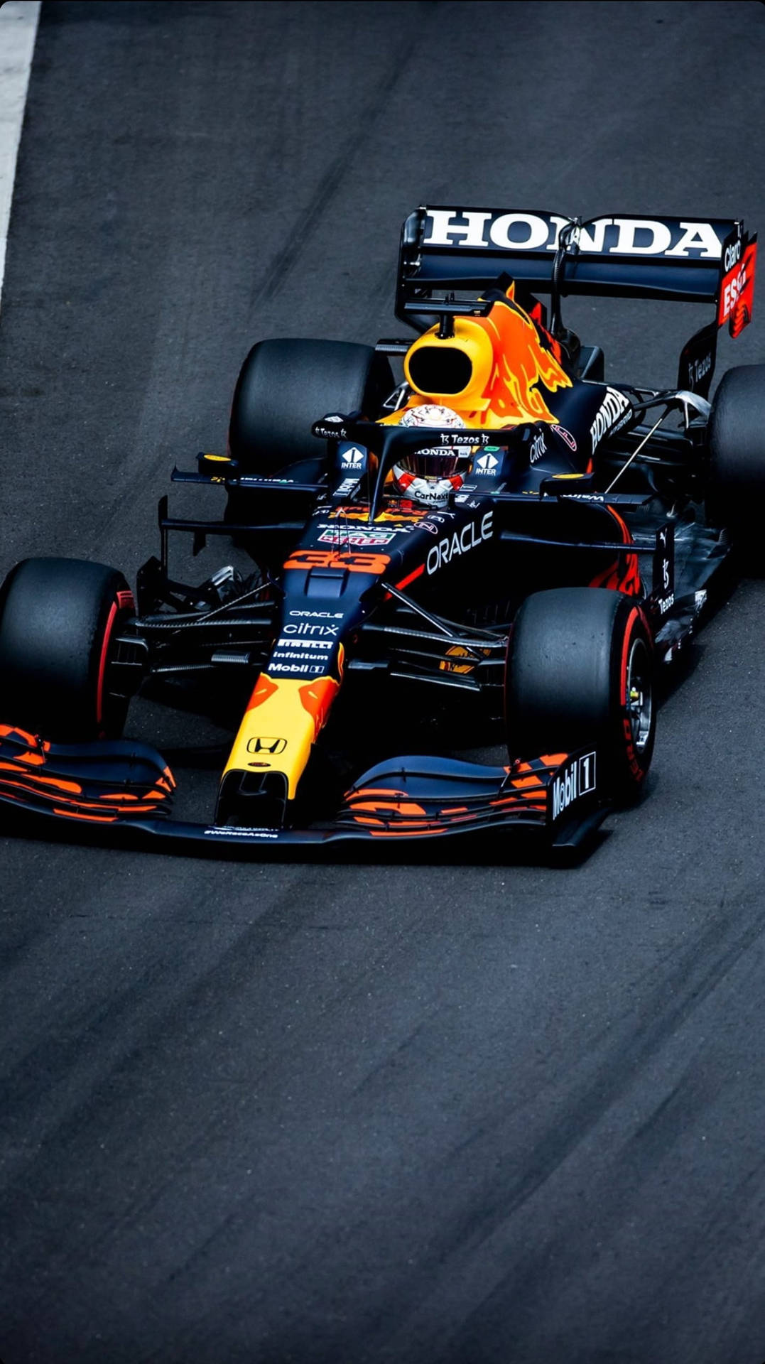 比賽期間，紅牛車隊的F1賽車在賽道上。 — F1 iPhone 壁紙 壁紙