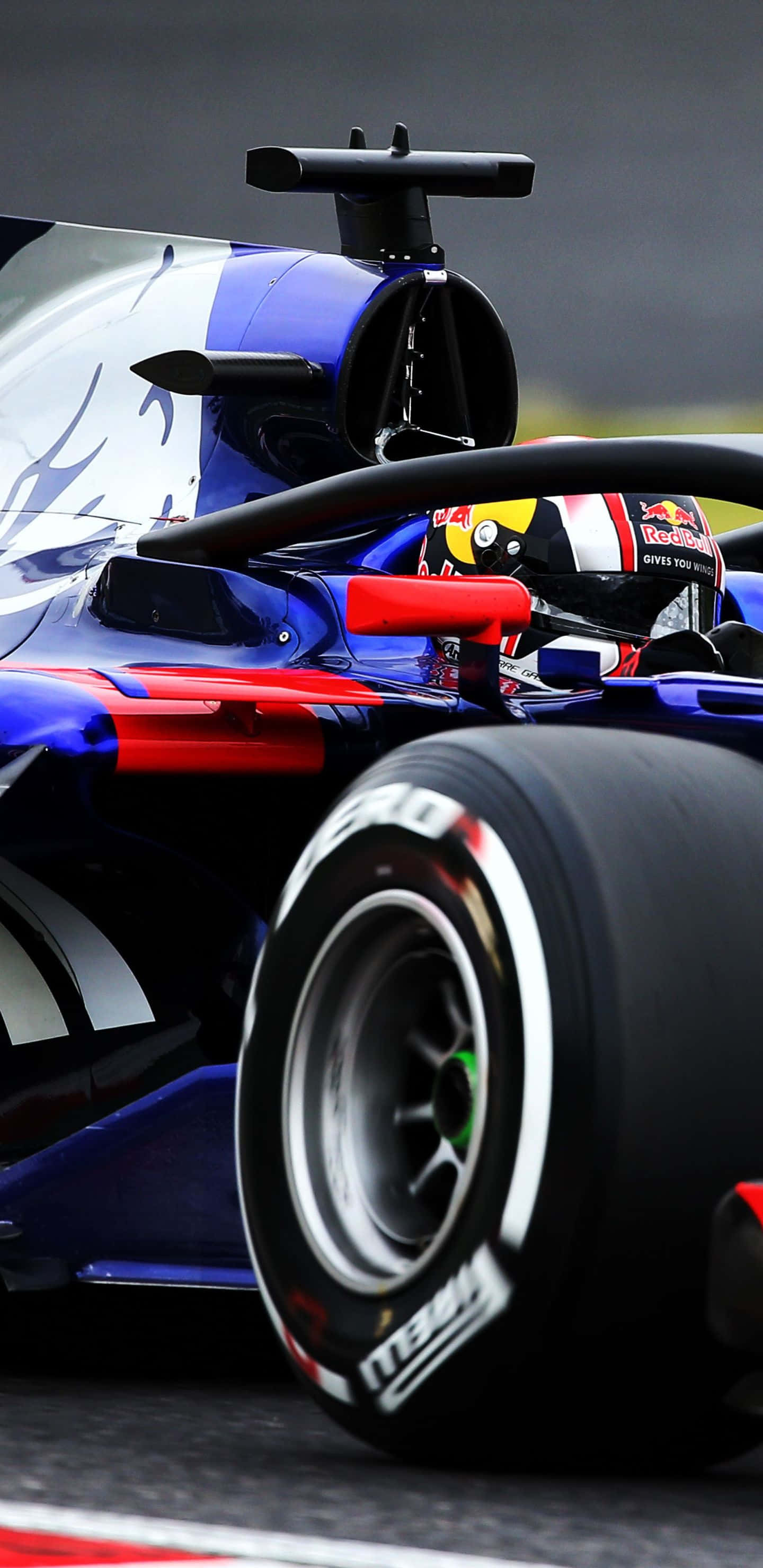 Formula 1 桌布 壁紙 — Red Bull 一級方程式賽車在賽道上疾馳的特寫，可見戴著頭盔的車手。