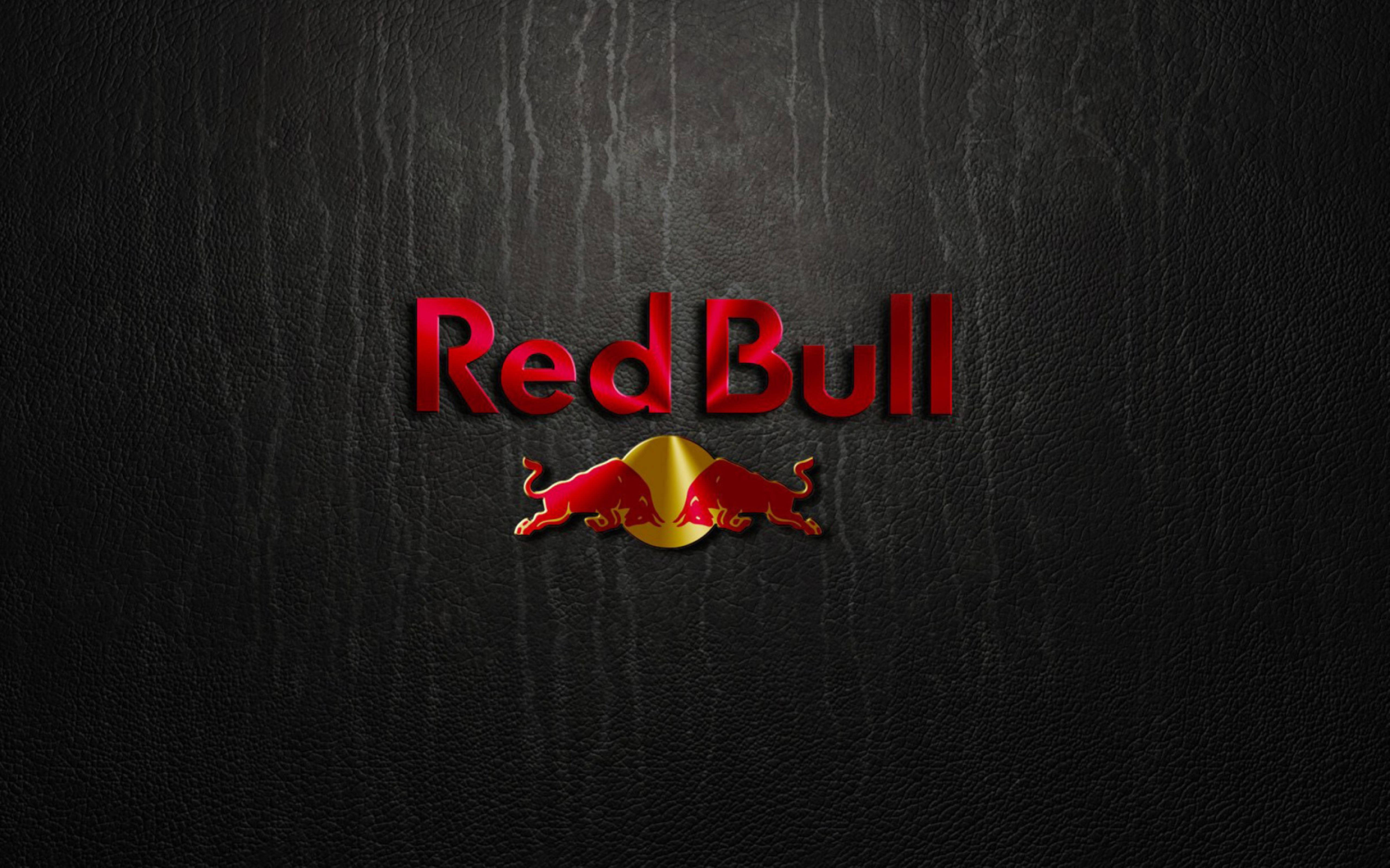 bull 桌布 壁紙 — Red Bull 標誌，兩頭衝鋒的紅色公牛位於金色圓圈中央，背景為深色紋理皮革。