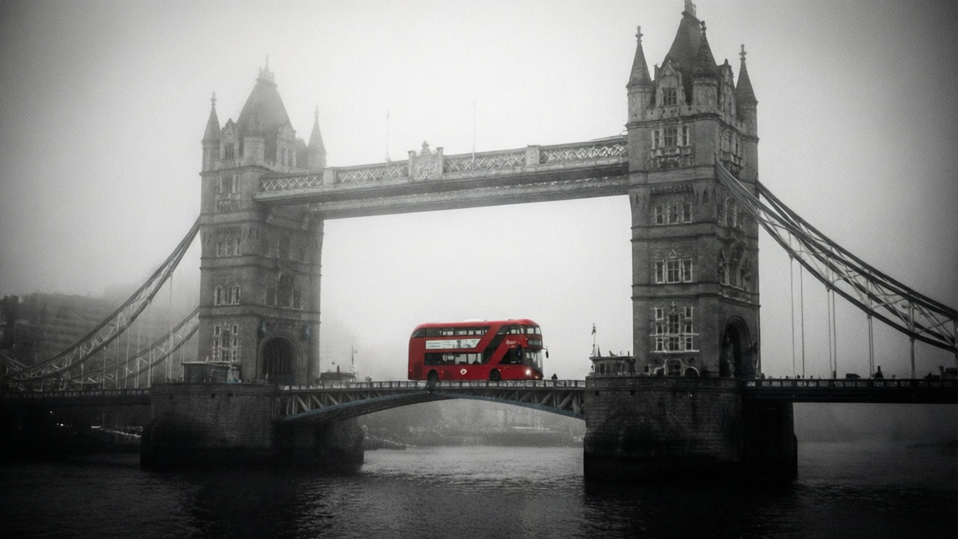 Foggy Tower Bridge 壁紙 — 一輛紅色雙層巴士穿過霧中的倫敦塔橋，橫跨泰晤士河，以單色調搭配選擇性色彩呈現。