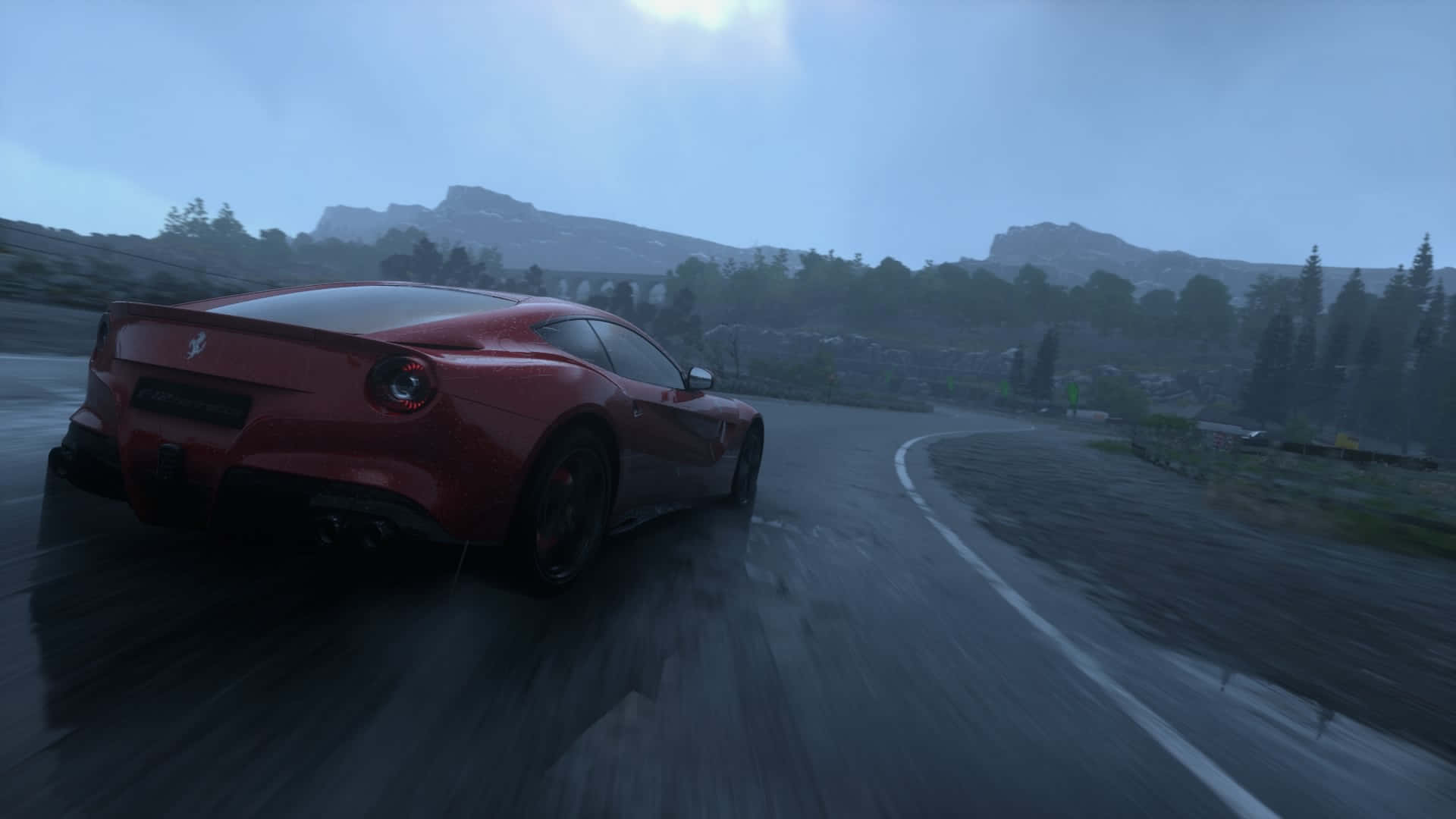 Ferrari F12 Berlinetta 桌布 壁紙 — 一輛紅色法拉利在灰色天空下，沿著潮濕的山路飛馳，周圍是霧氣籠罩的樹木和遠山。