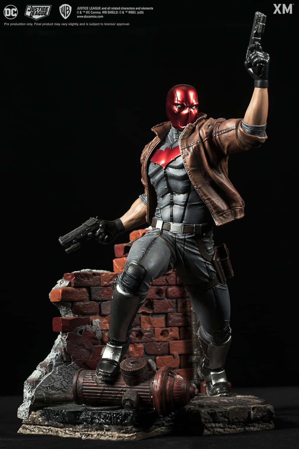 紅頭罩 桌布 壁紙 — Red Hood 雕像站在瓦礫上，手持兩把手槍，背景為黑色。