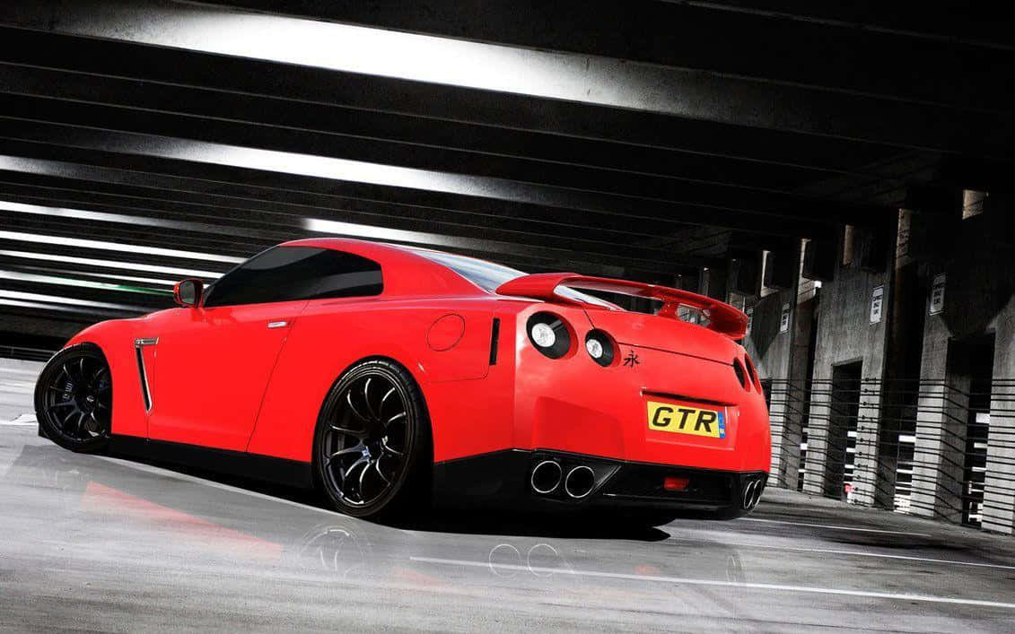 汽車 4K 桌布 壁紙 — 一輛鮮紅色的日產GT-R跑車停放在燈光昏暗的混凝土天橋下，帶有動態模糊條紋。