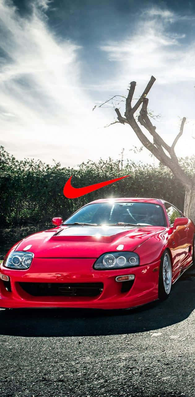 紅色跑車帶有Nike標誌，背景為天空和樹木 — Toyota Supra 壁紙